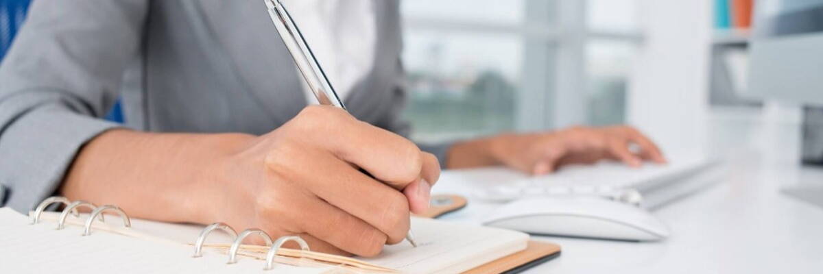 a person sitting at a desk writing 